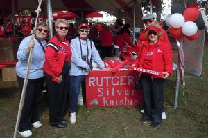 Five people standing around a 'Rutgers Silver Knights' sign.